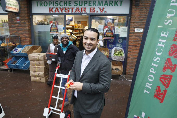 In ‘zijn’ Bijlmermeer, waar mensen uit alle windstreken er vaak voor kiezen om er zelf iets van te maken. Zoals Stella Chido (linksachter) met haar tropische supermarkt. 