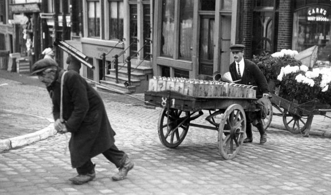 De Amsterdamse Kikki de kargadoor trekt de handkar met blikken olie over de Prinsengracht