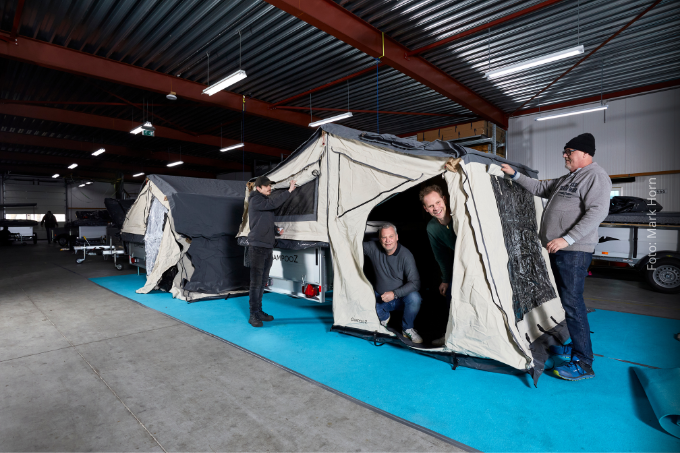 Gert IJszenga (links in de tent) zet met zijn bedrijf Campooz nét dat stapje extra om mensen met afstand tot de arbeidsmarkt aan het werk te helpen