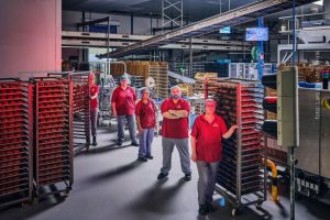 Werknemers van bakkerij Amarant staan te wachten voor een verkeerslicht dat op rood staat. Het staat symbool voor de obstakels - in dit geval netcongestie - die bedrijven in Nederland tegengekomen in hun pad op weg naar verduurzaming